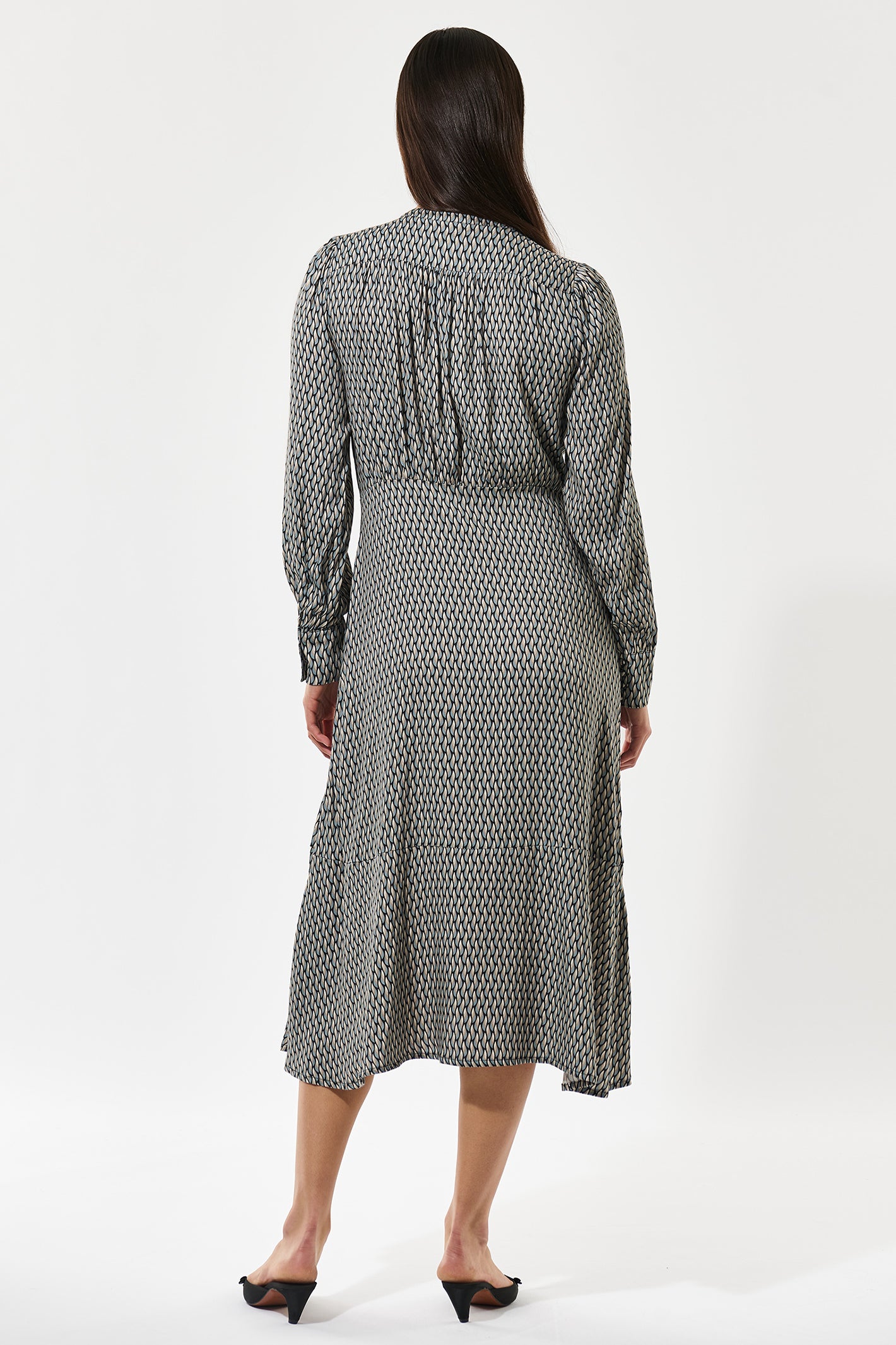 Woman wearing a patterned dress on a white background
