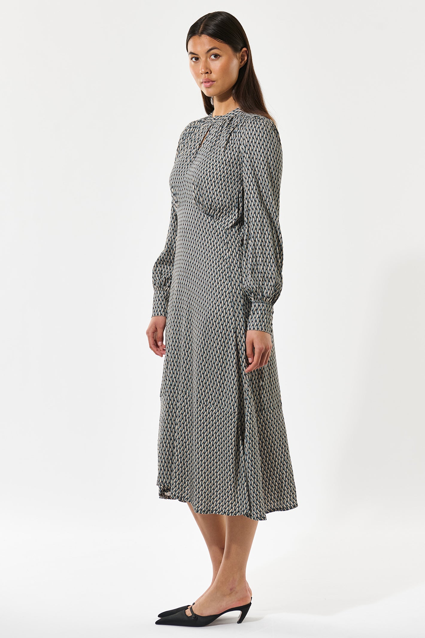 Woman wearing a patterned dress on a white background