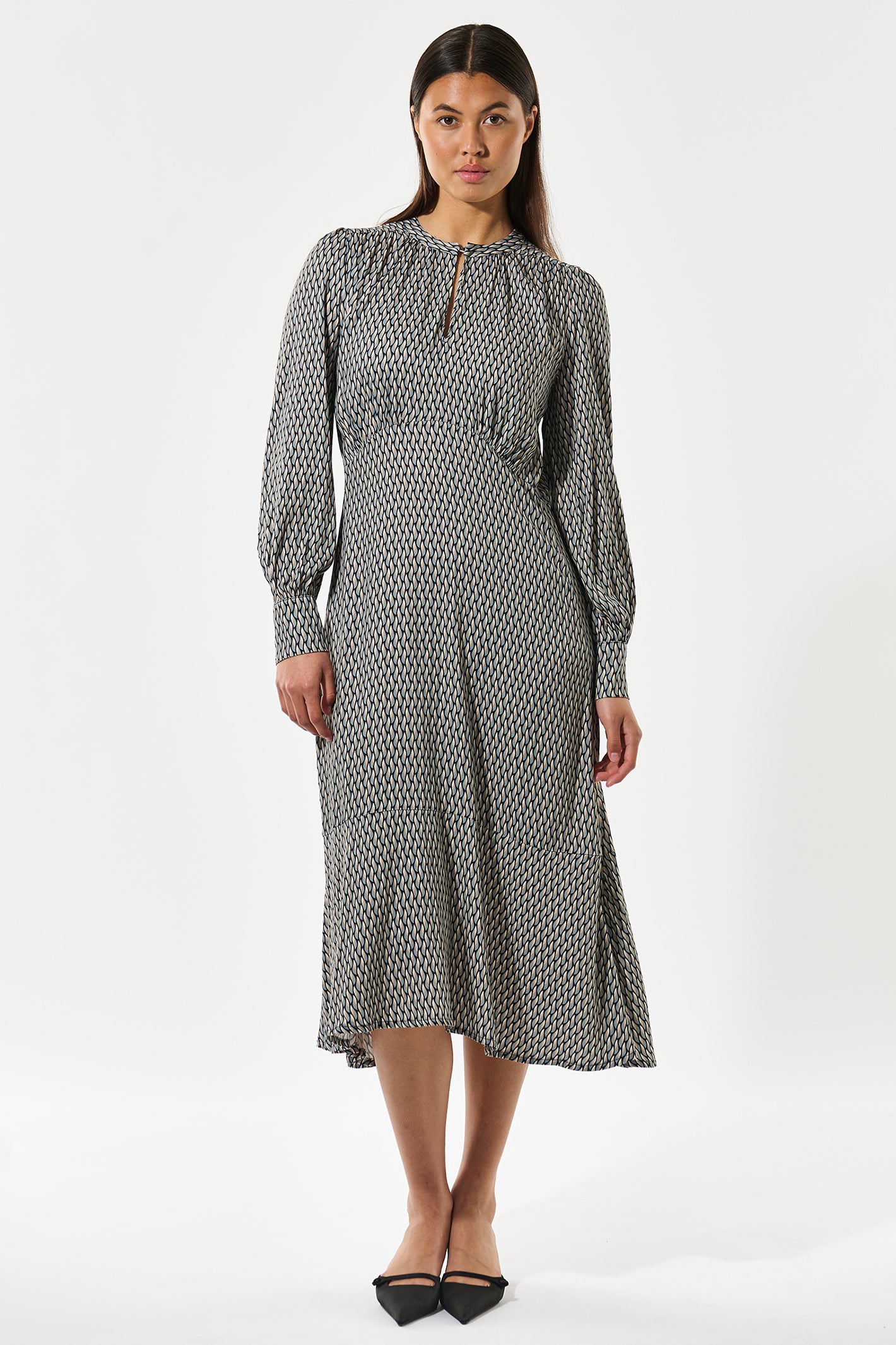 Woman wearing a patterned dress on a white background