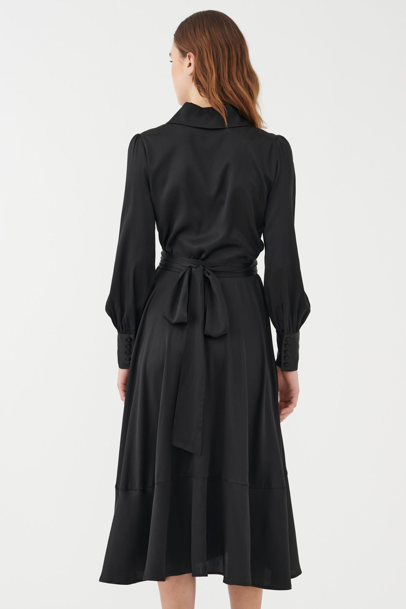 Black dress with a belt worn by a model on a white background