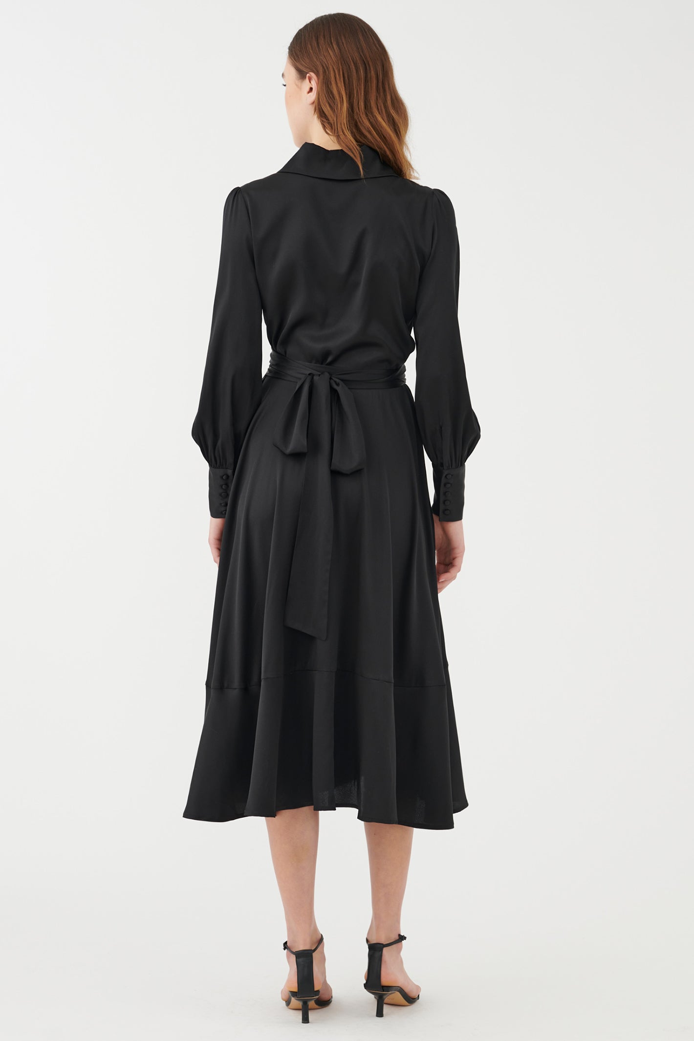 Black dress worn by a model on a white background
