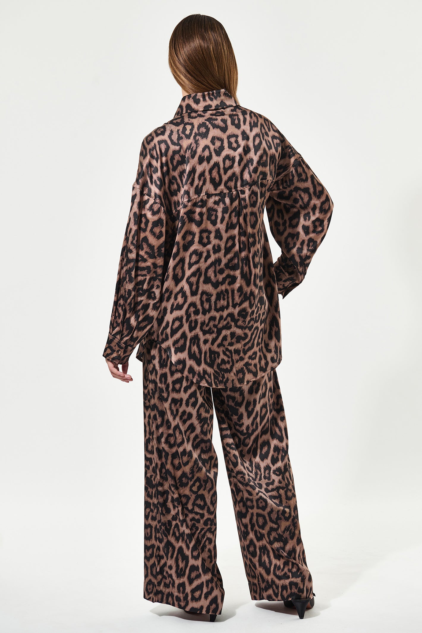 Person wearing a leopard print outfit on a white background