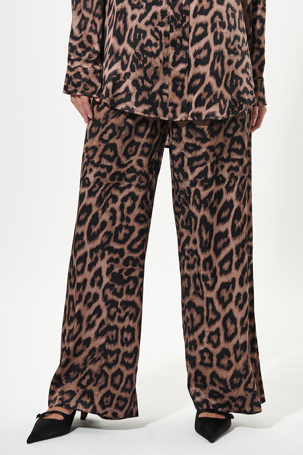 Leopard print pants worn by a person on a white background
