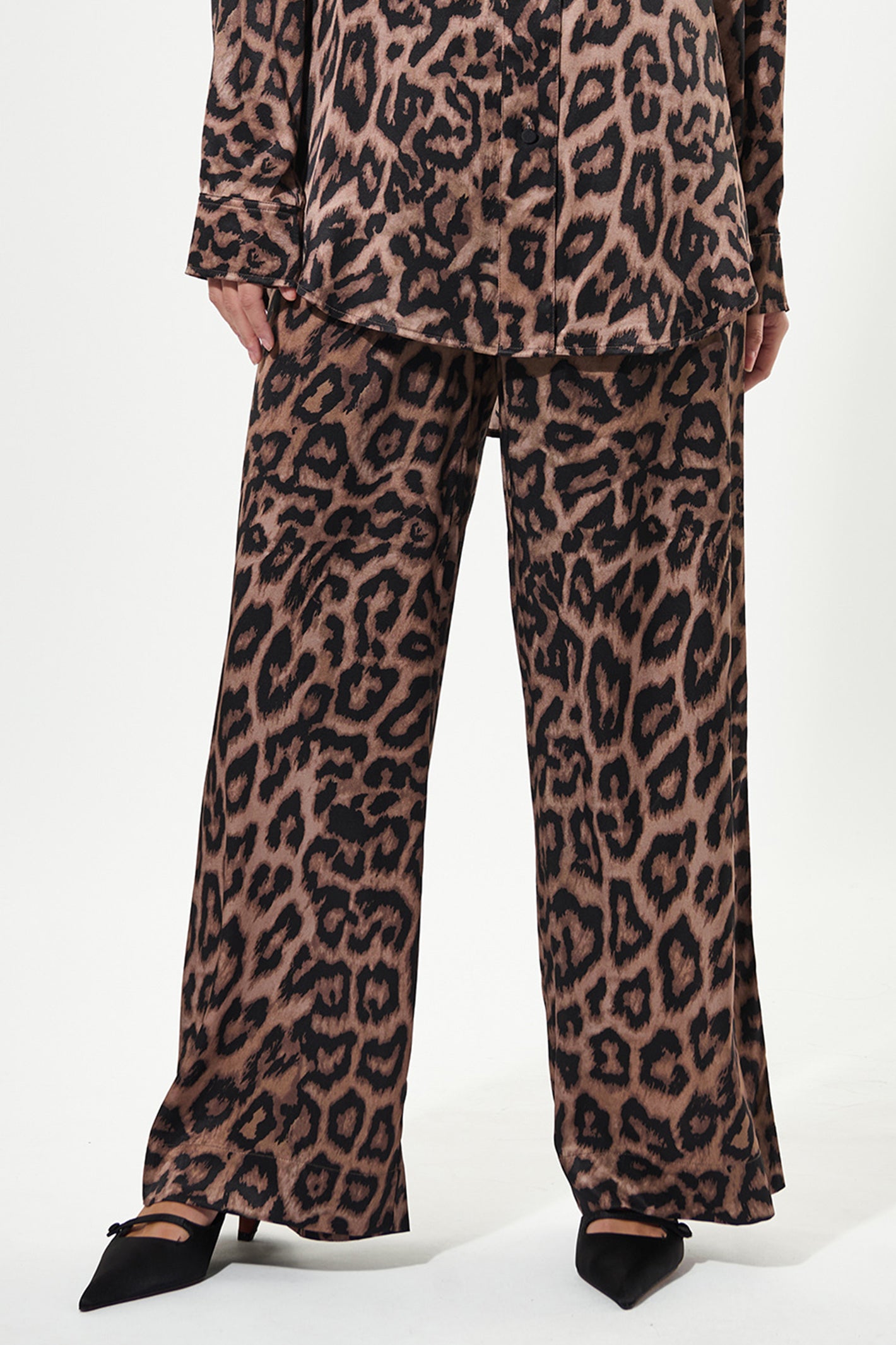 Leopard print pants worn by a person on a white background