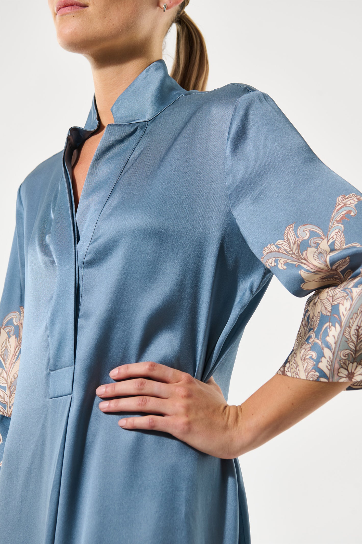 Light blue dress with intricate arm embroidery on a plain background