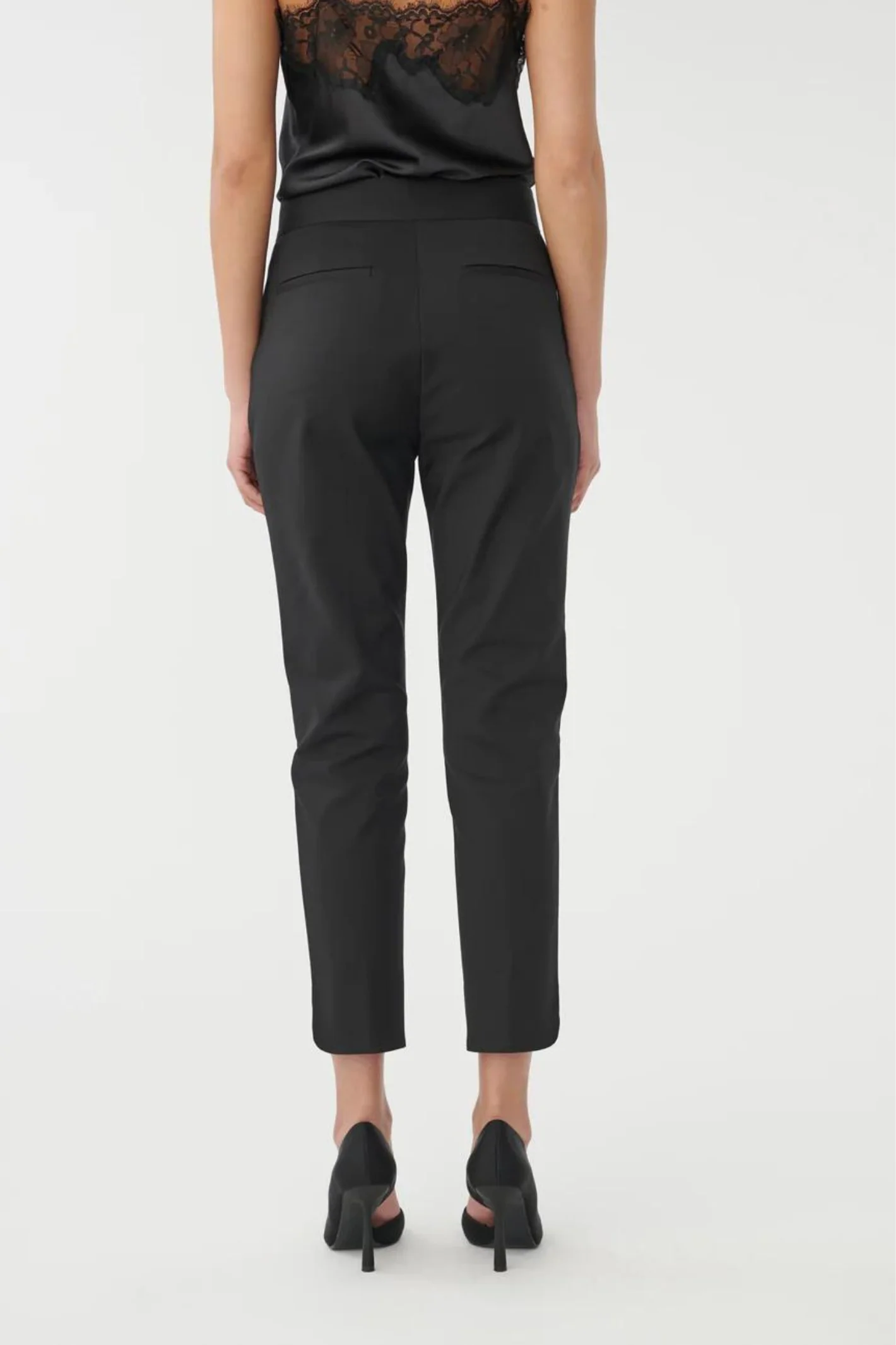 Person wearing black high-waisted pants on a white background