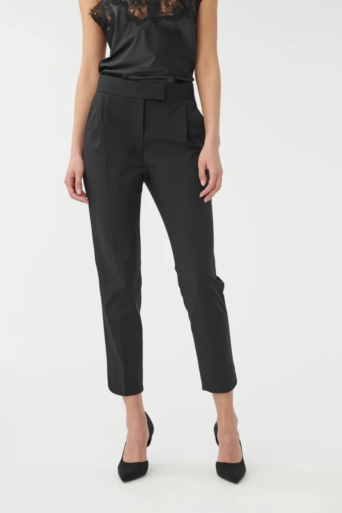 Person wearing black high-waisted pants on a white background