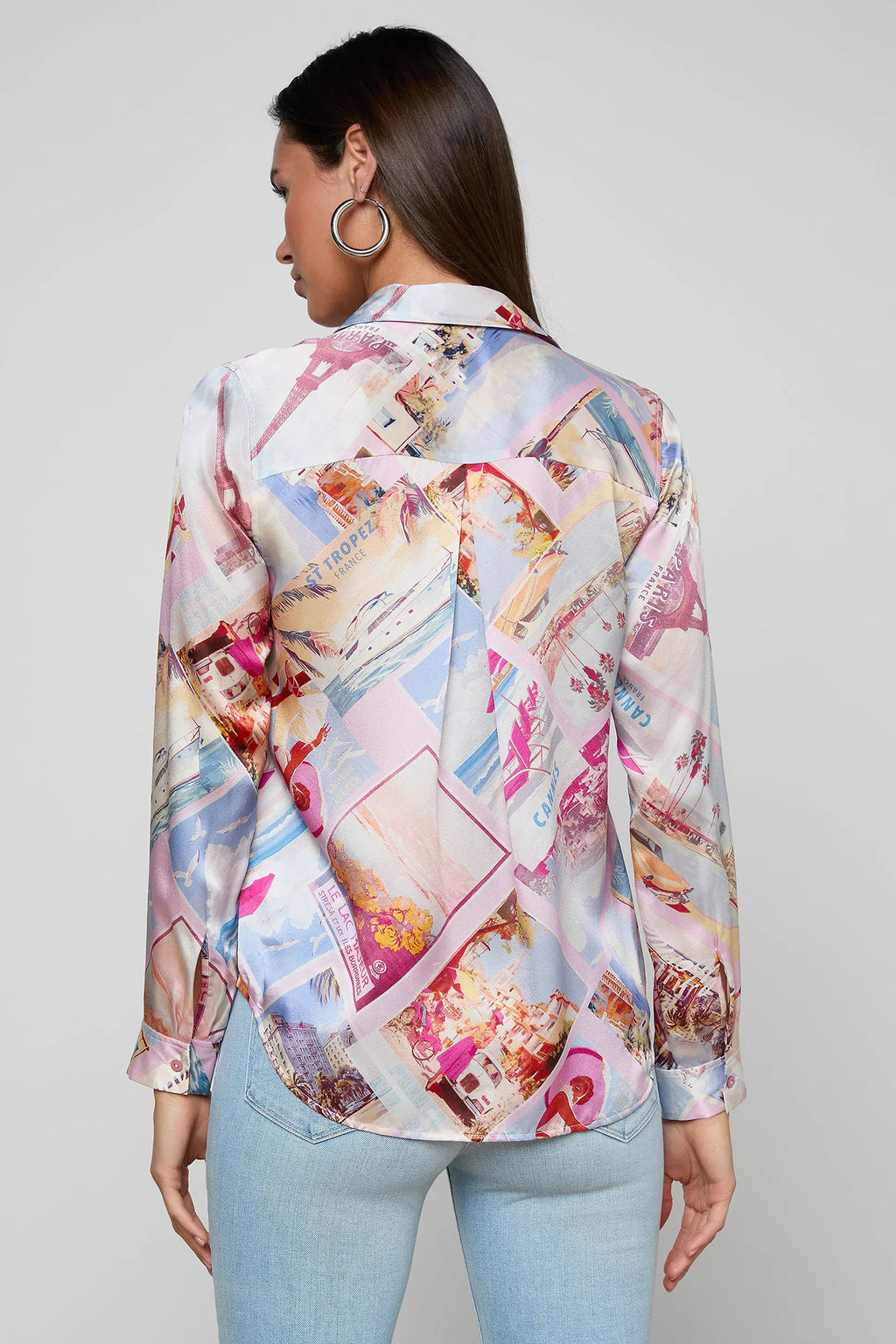 Woman wearing a colorful patterned blouse against a plain background