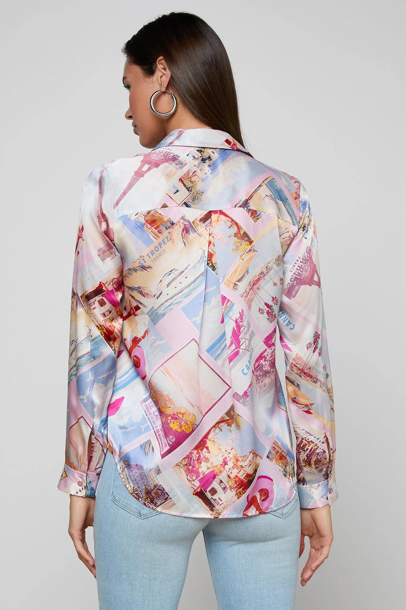 Woman wearing a colorful patterned blouse against a plain background