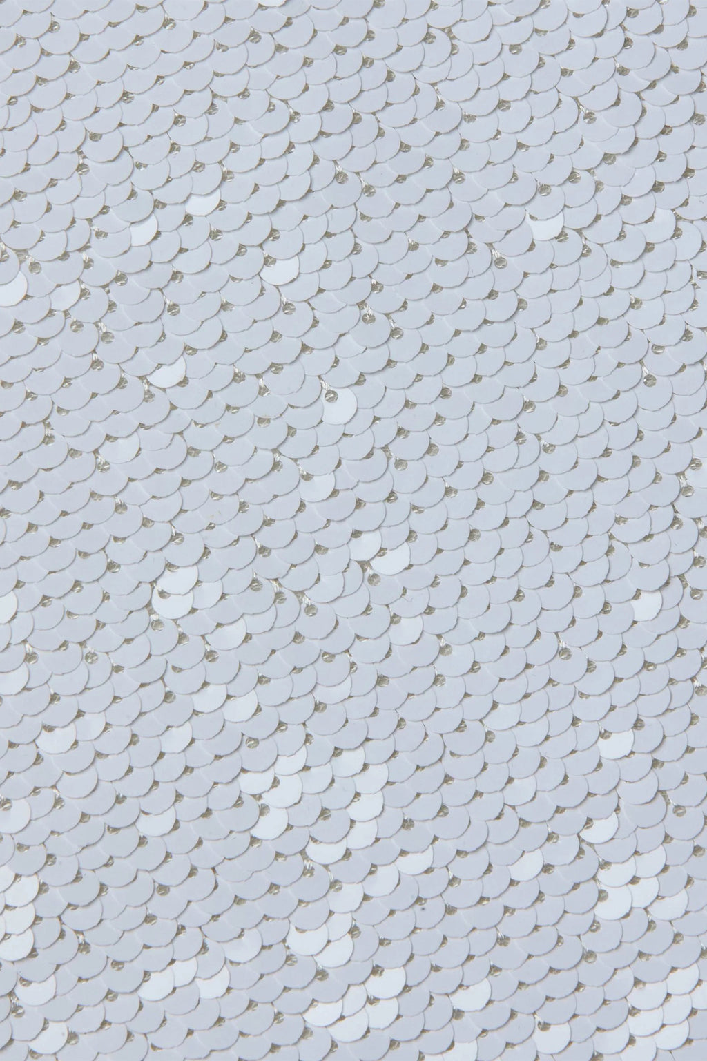 Close-up of a textured white sequin surface with small circular patterns