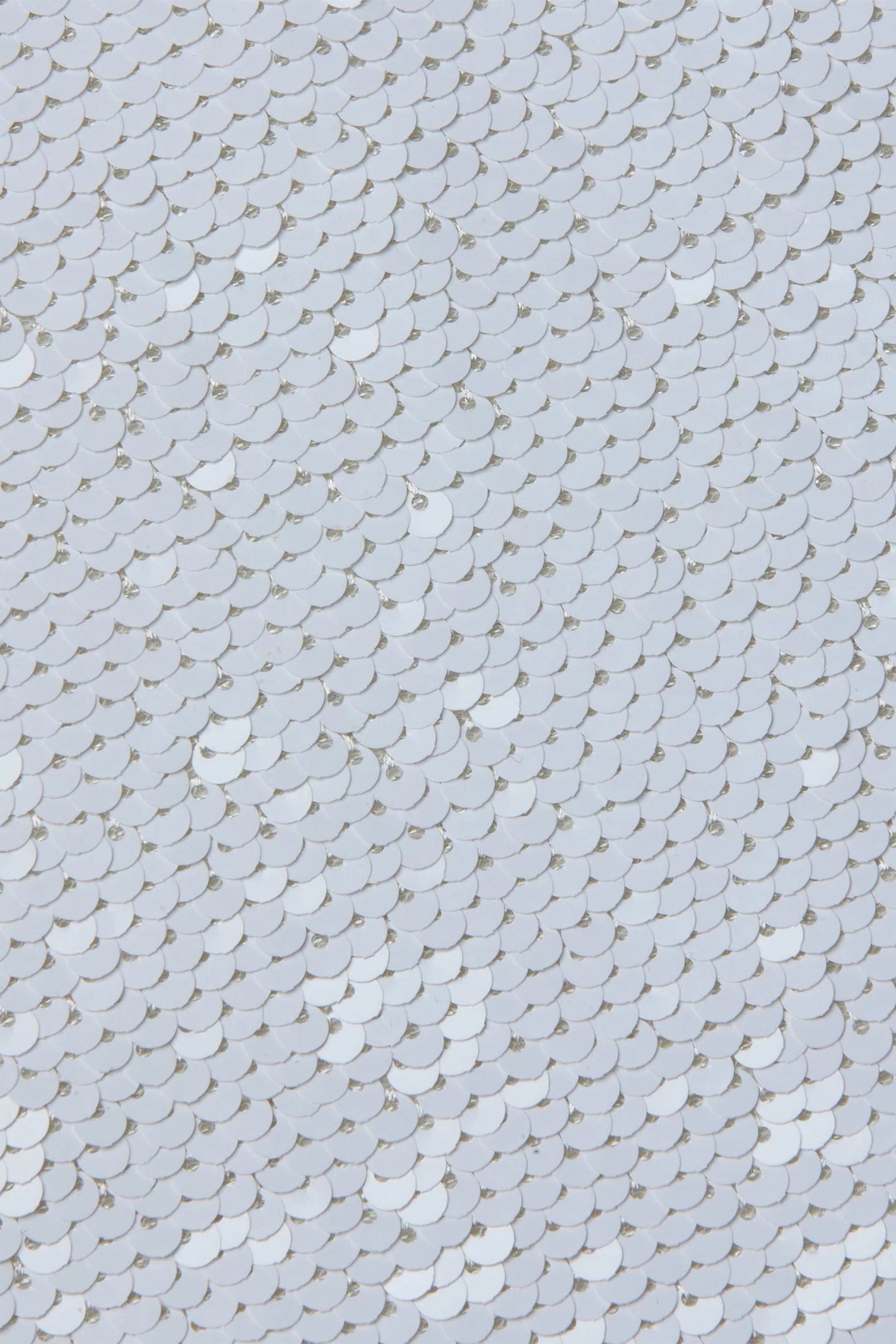 Close-up of a textured white sequin surface with small circular patterns