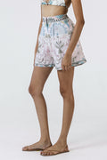 Person wearing a patterned skirt and sandals on a white background