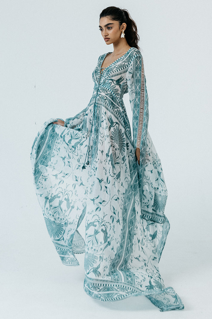 Woman wearing a long, patterned dress on a white background