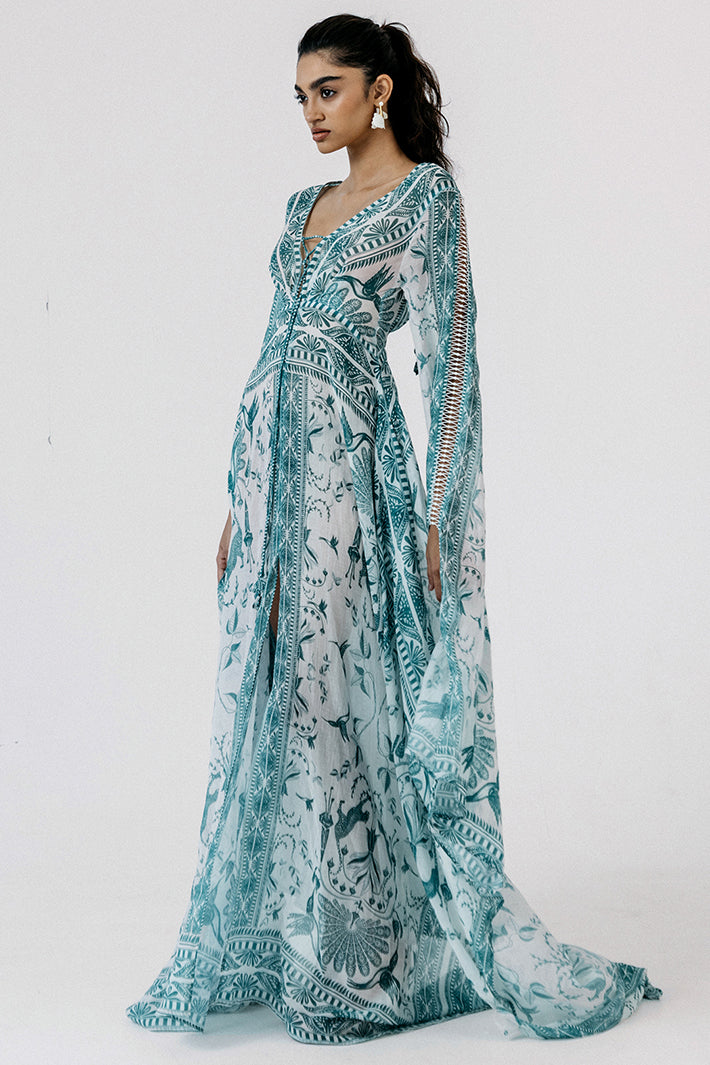 Woman wearing a long, patterned dress with a white background