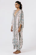 Woman wearing a patterned kaftan on a white background