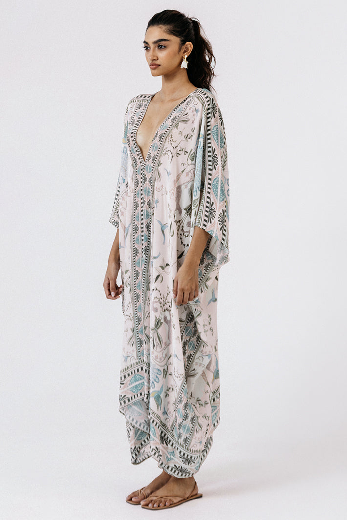 Woman wearing a patterned kaftan on a white background