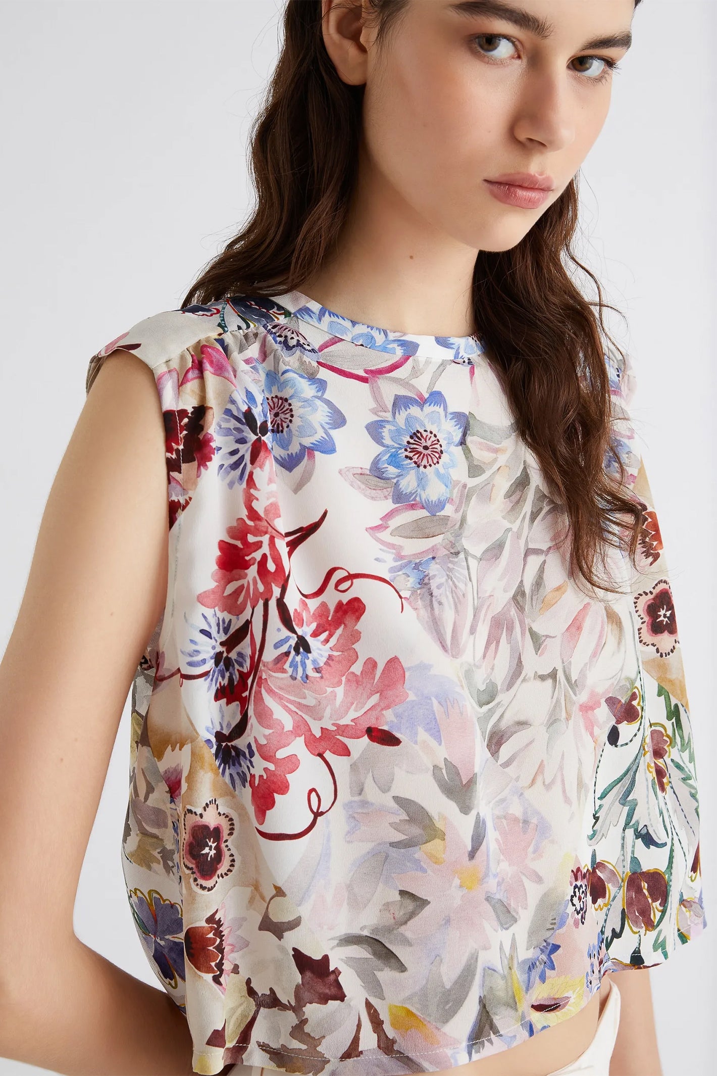 Woman wearing a floral blouse with a white background
