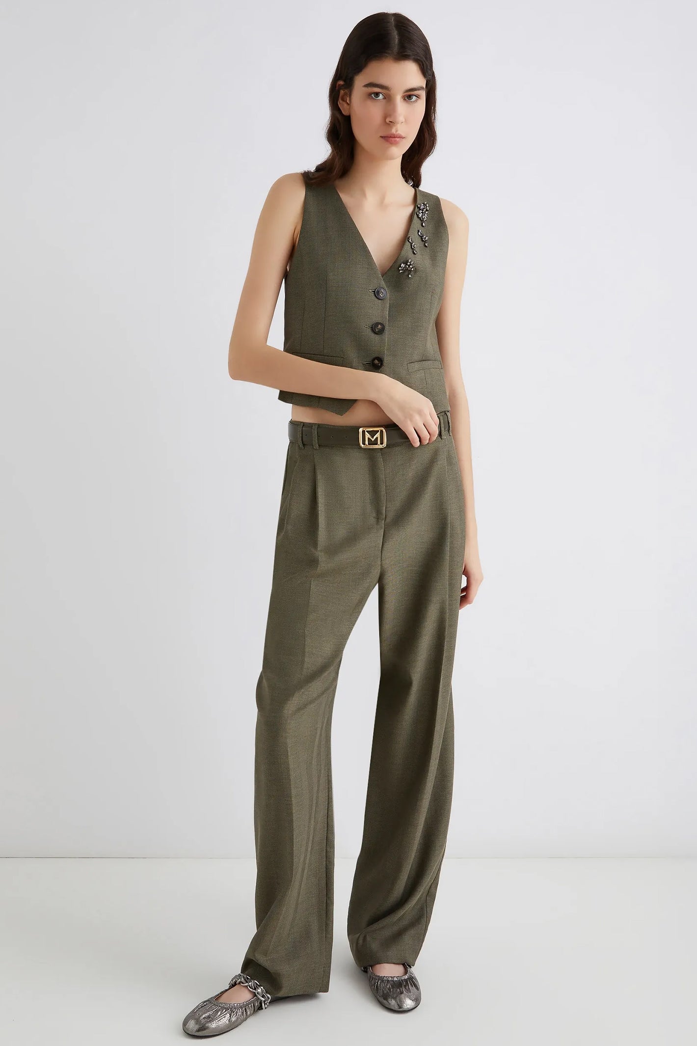 Woman wearing a green vest and pants set on a white background