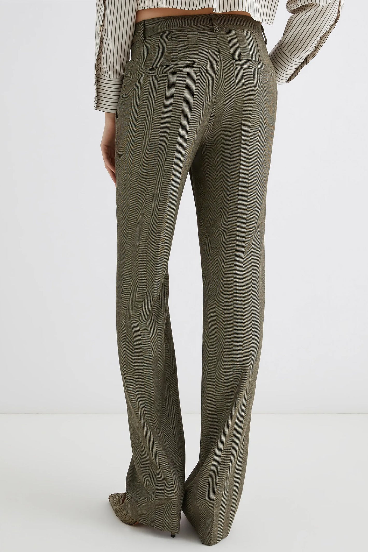 Green pants worn by a person on a white background