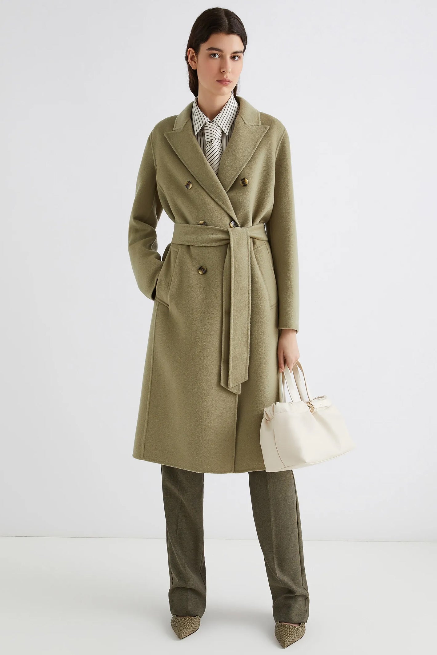 Person wearing a green coat with a white background