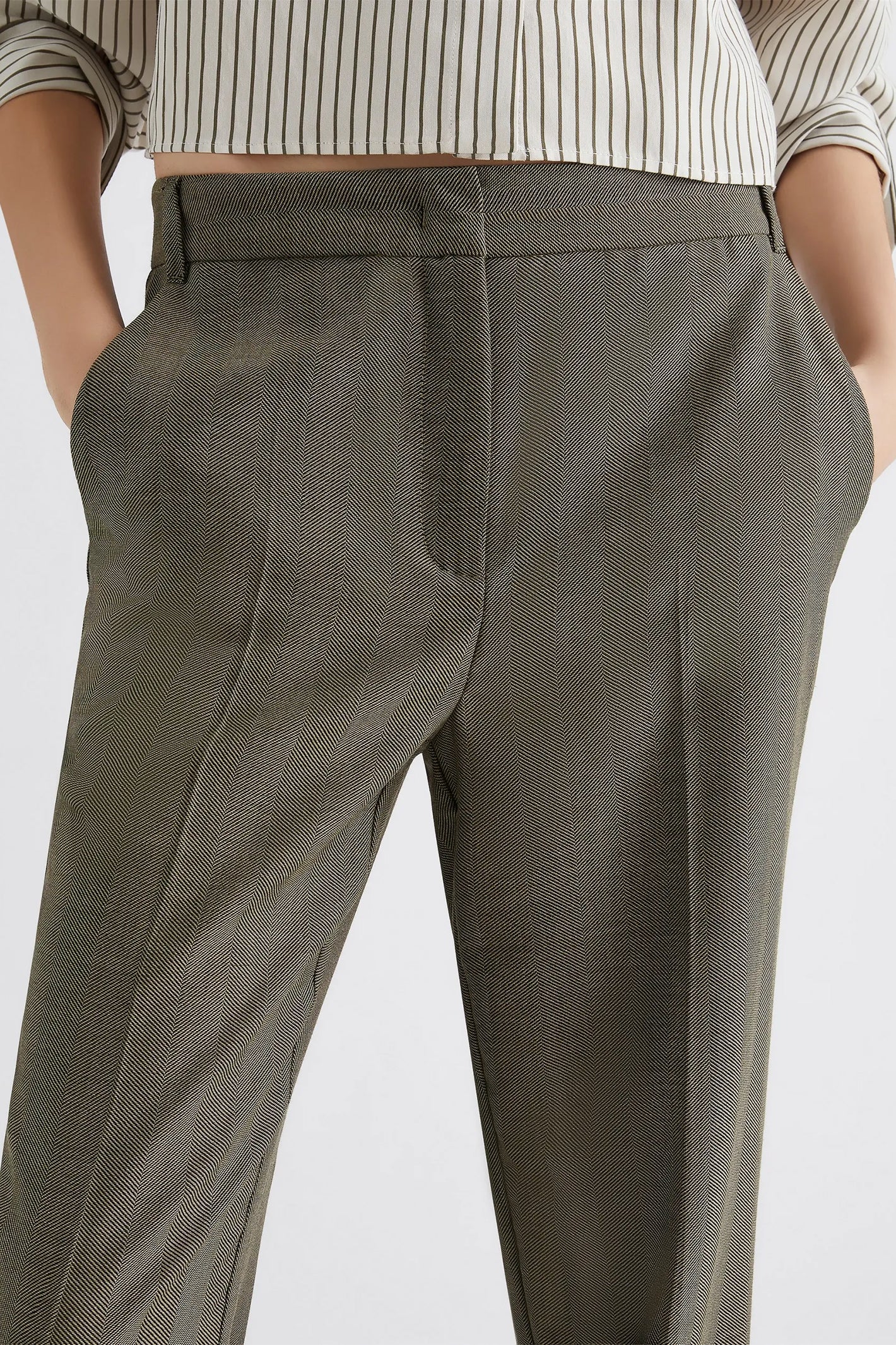 Green pants worn by a person on a white background