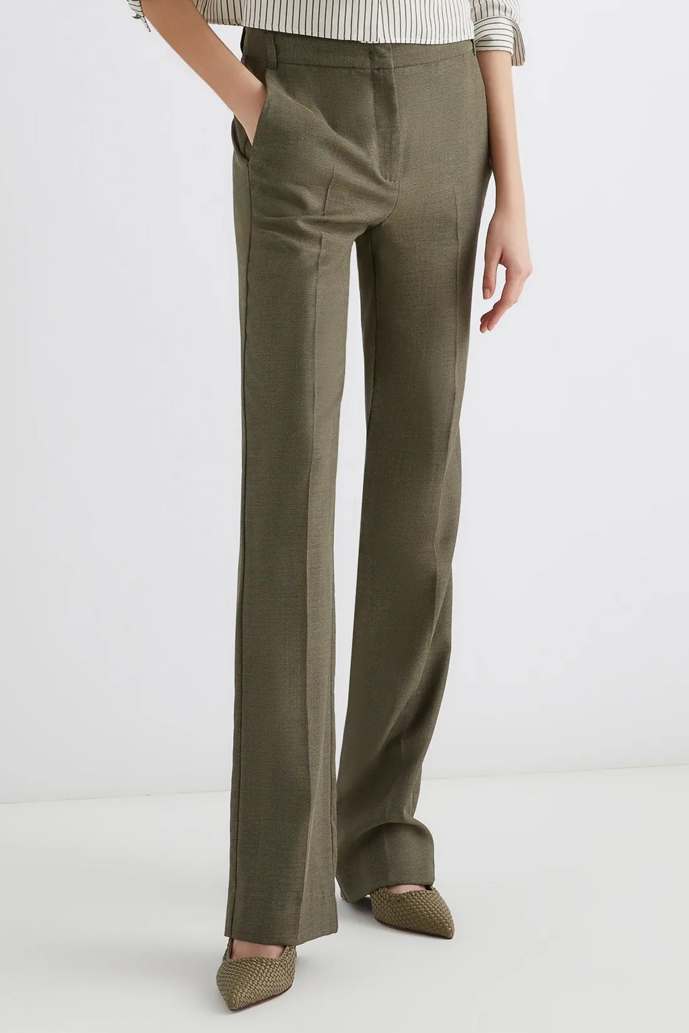 Person wearing olive green pants on a white background