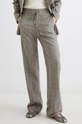 Person wearing gray checkered pants on a white background