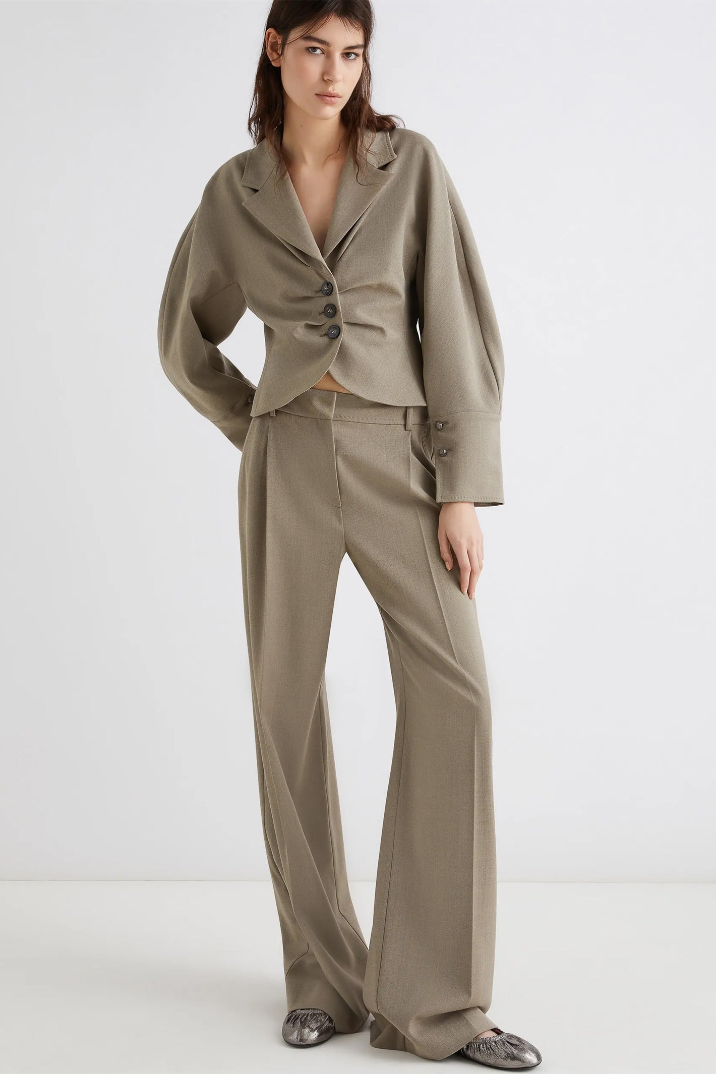 Woman wearing a beige suit on a white background