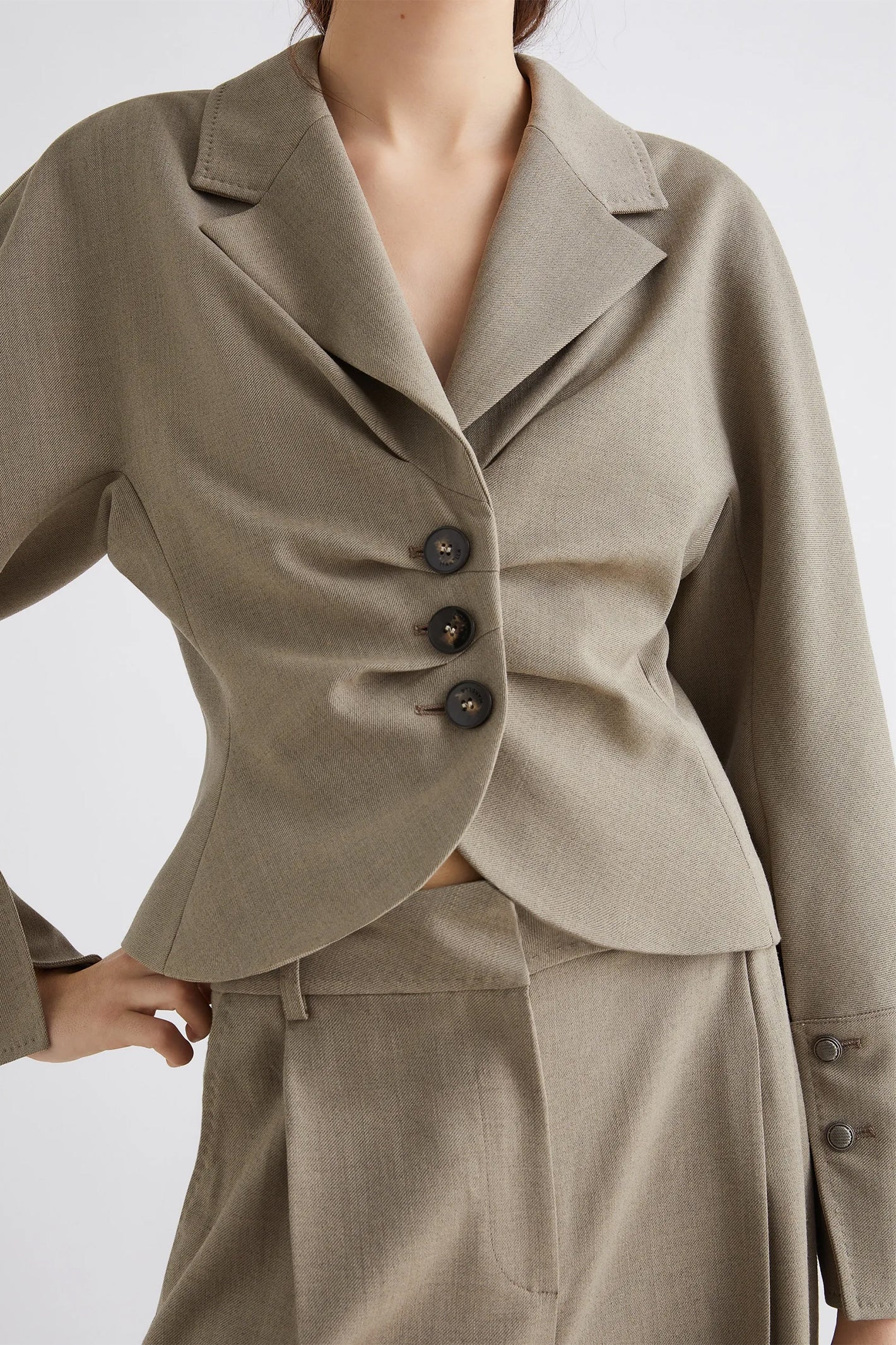 Beige suit jacket with buttons on a plain background