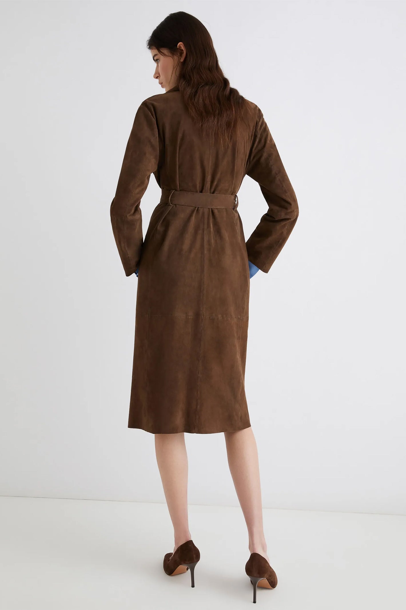 Woman wearing a brown dress with a belt on a white background