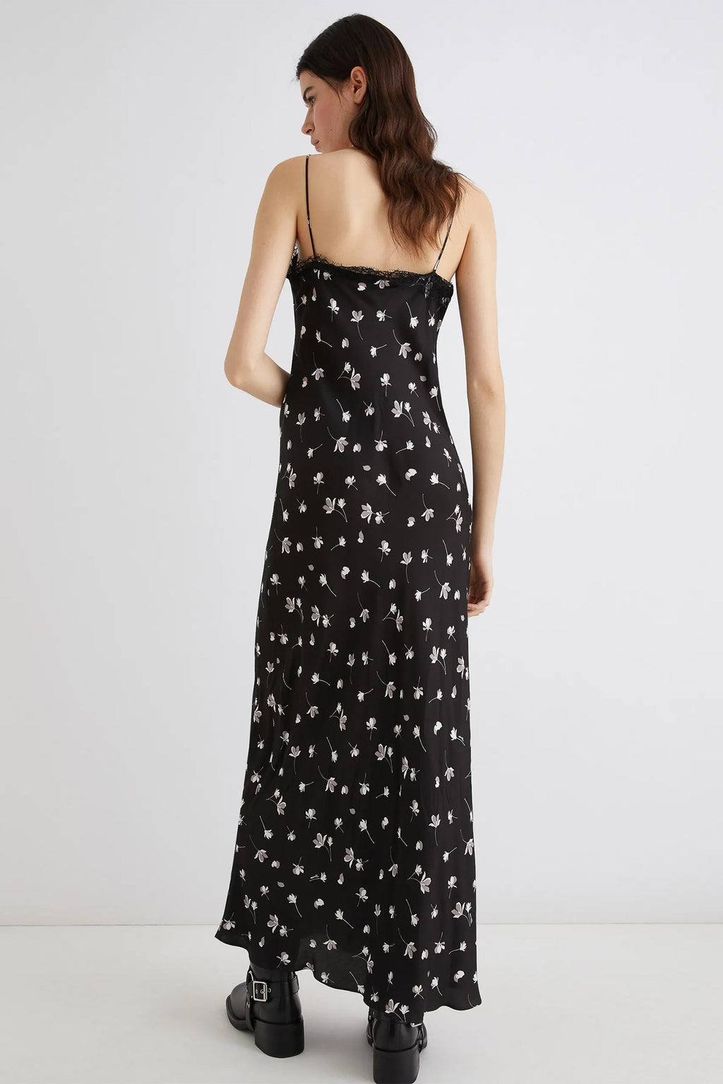 Woman wearing a black floral dress on a white background