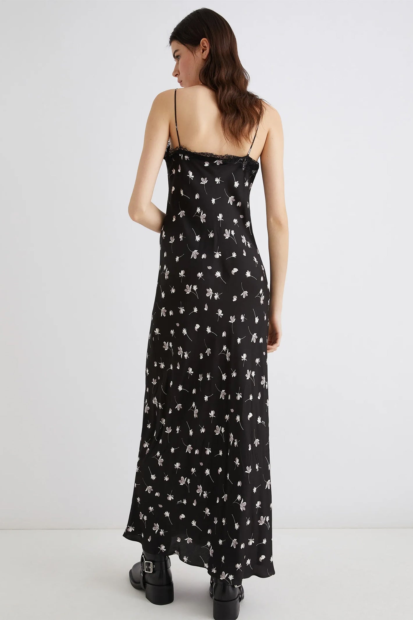 Woman wearing a black floral dress on a white background