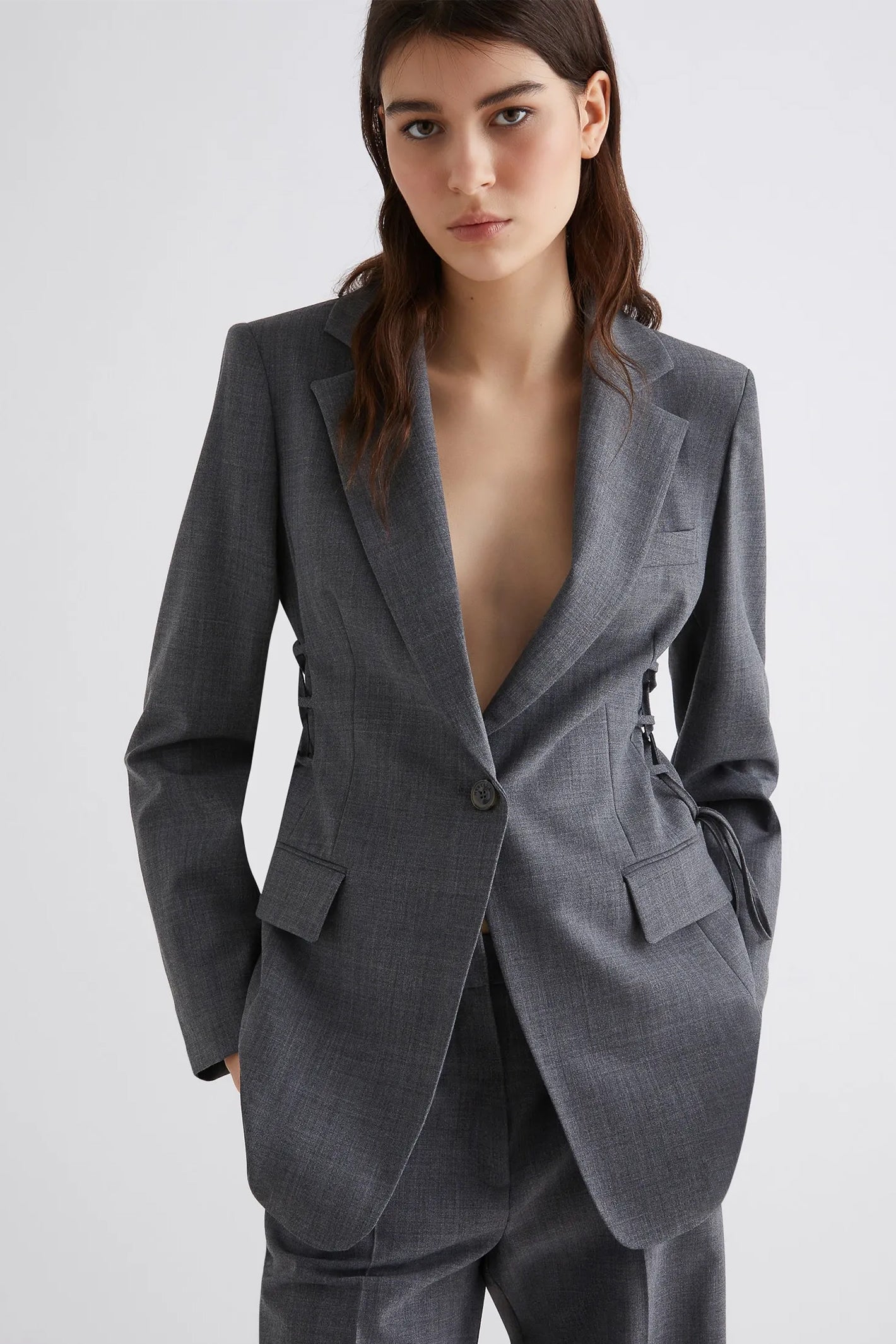 Woman wearing a gray suit with a white background