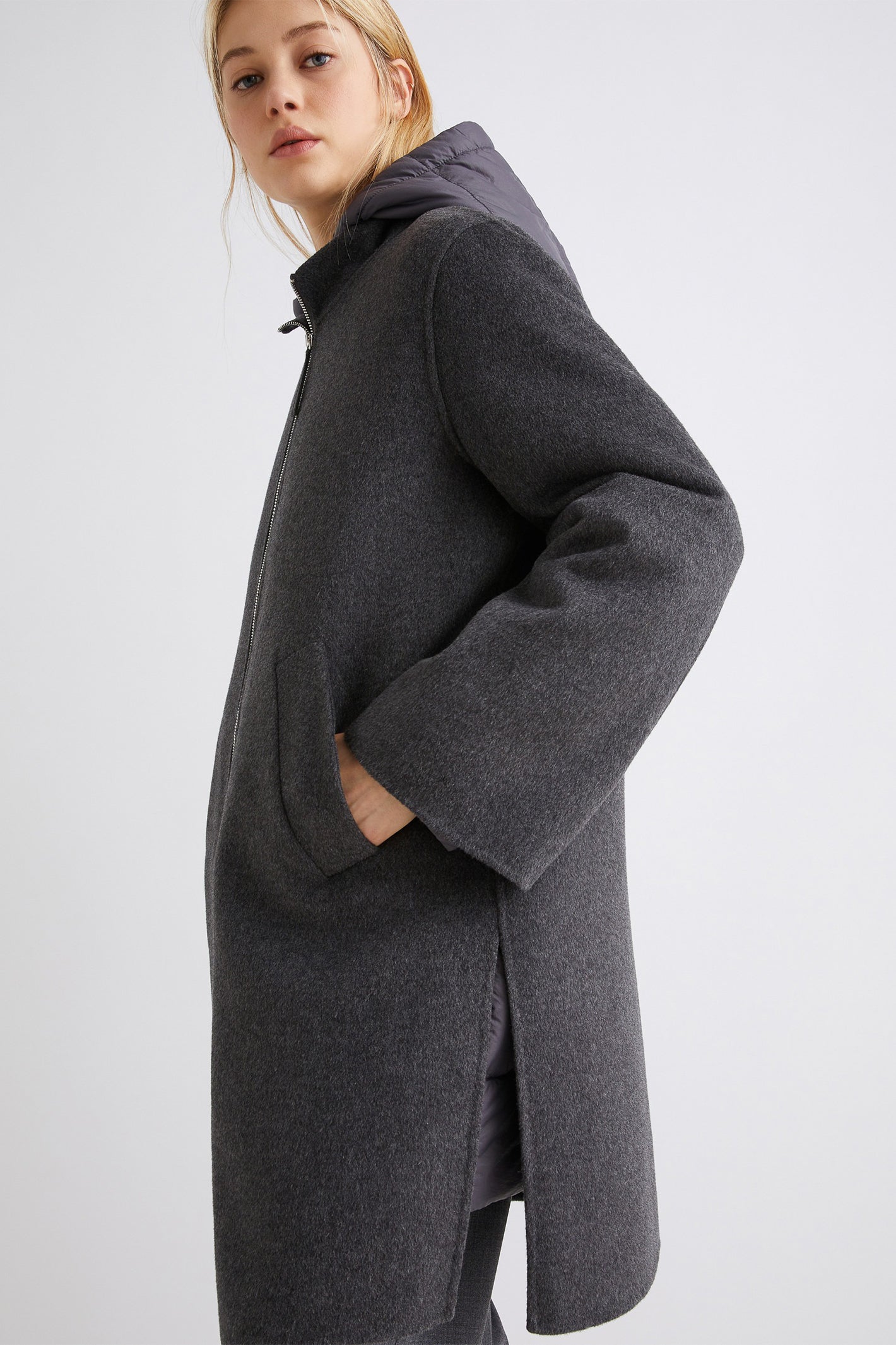 Person wearing a gray coat on a white background