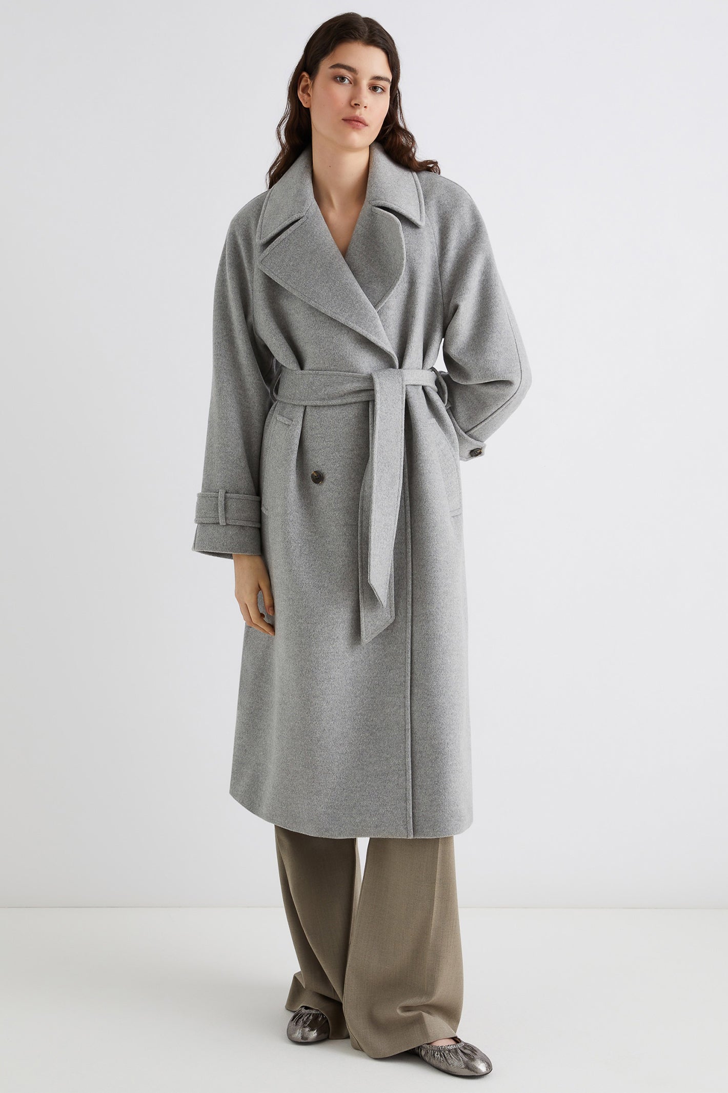 Woman wearing a gray coat with a white background