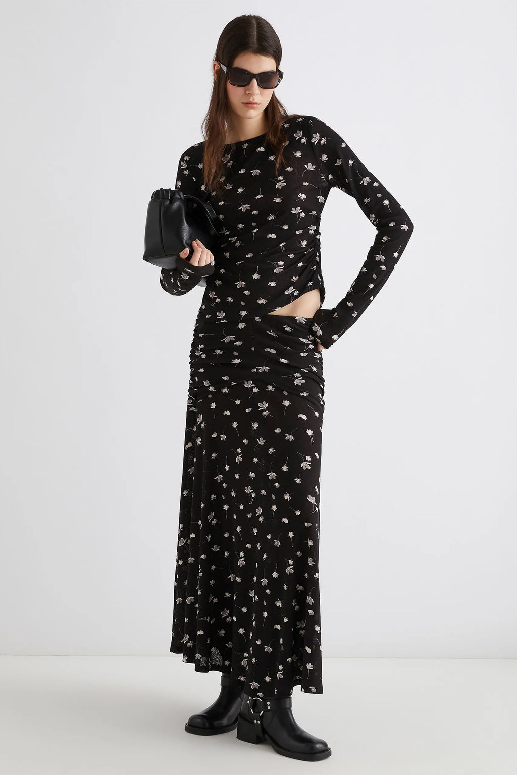 Woman wearing a black floral dress with a white background