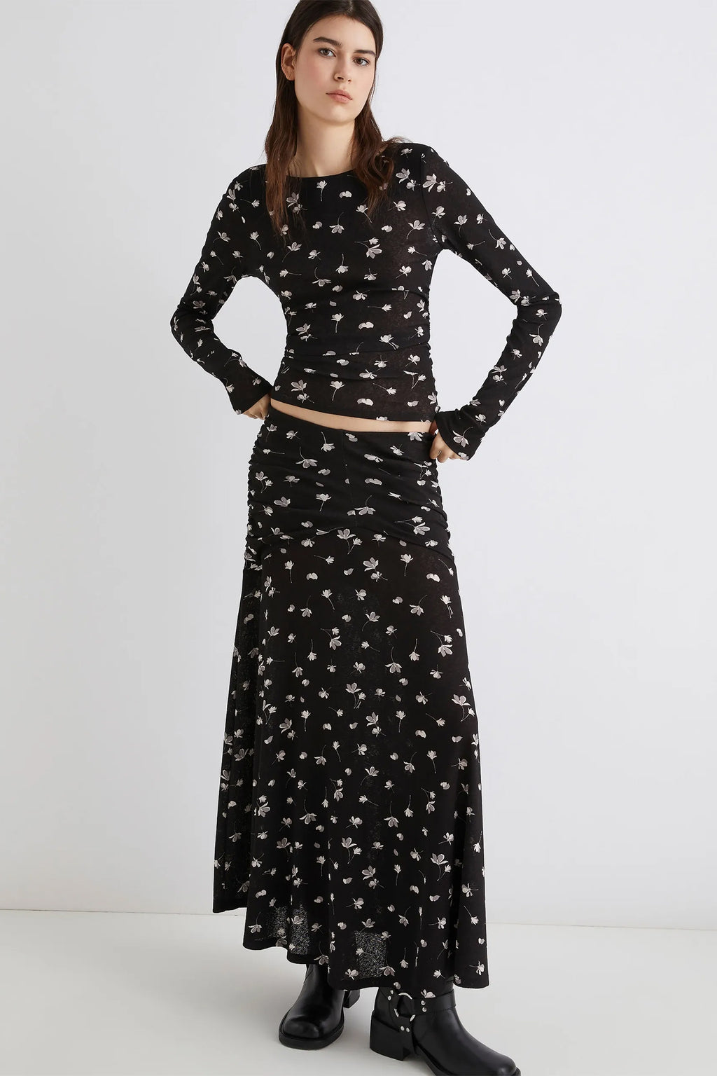 Woman wearing a black floral dress with a white background