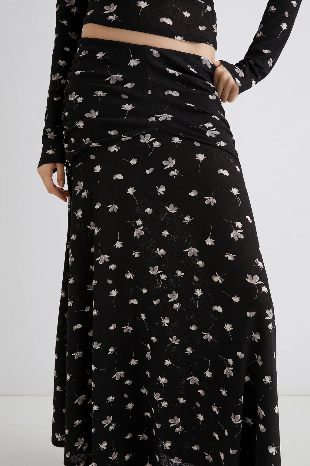 Black floral dress worn by a person on a white background