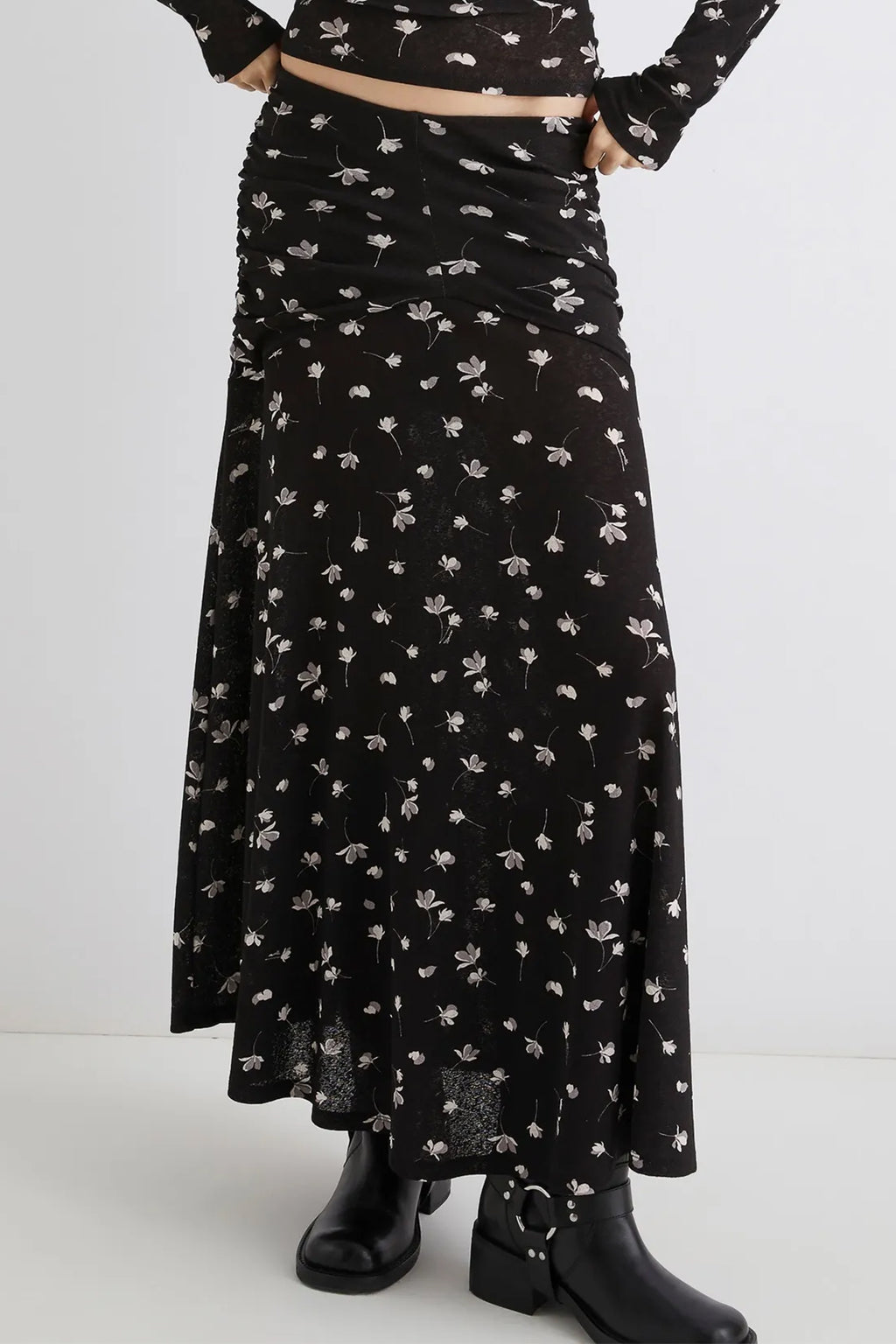 Person wearing a black floral dress with a white background